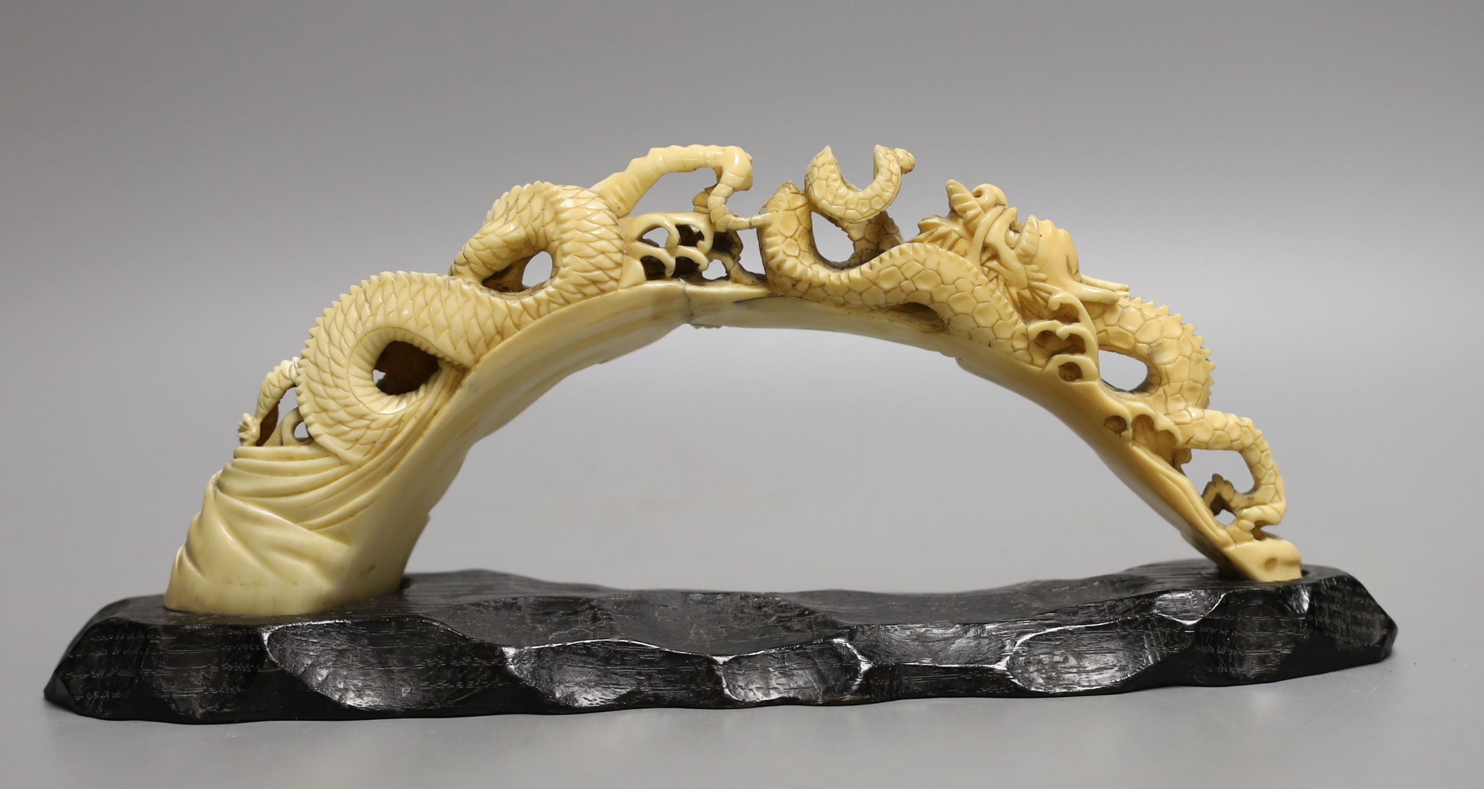 A Japanese boars tusk carving of two confronting dragons, Meiji period - 12cm high